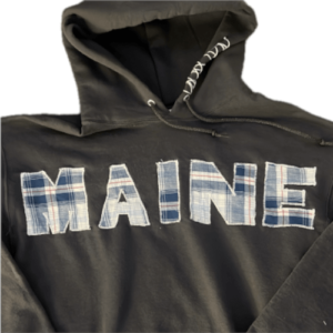 Front facing side of hoodie, with the word "MAINE" stitched onto the clothing with patchwork styled fabric